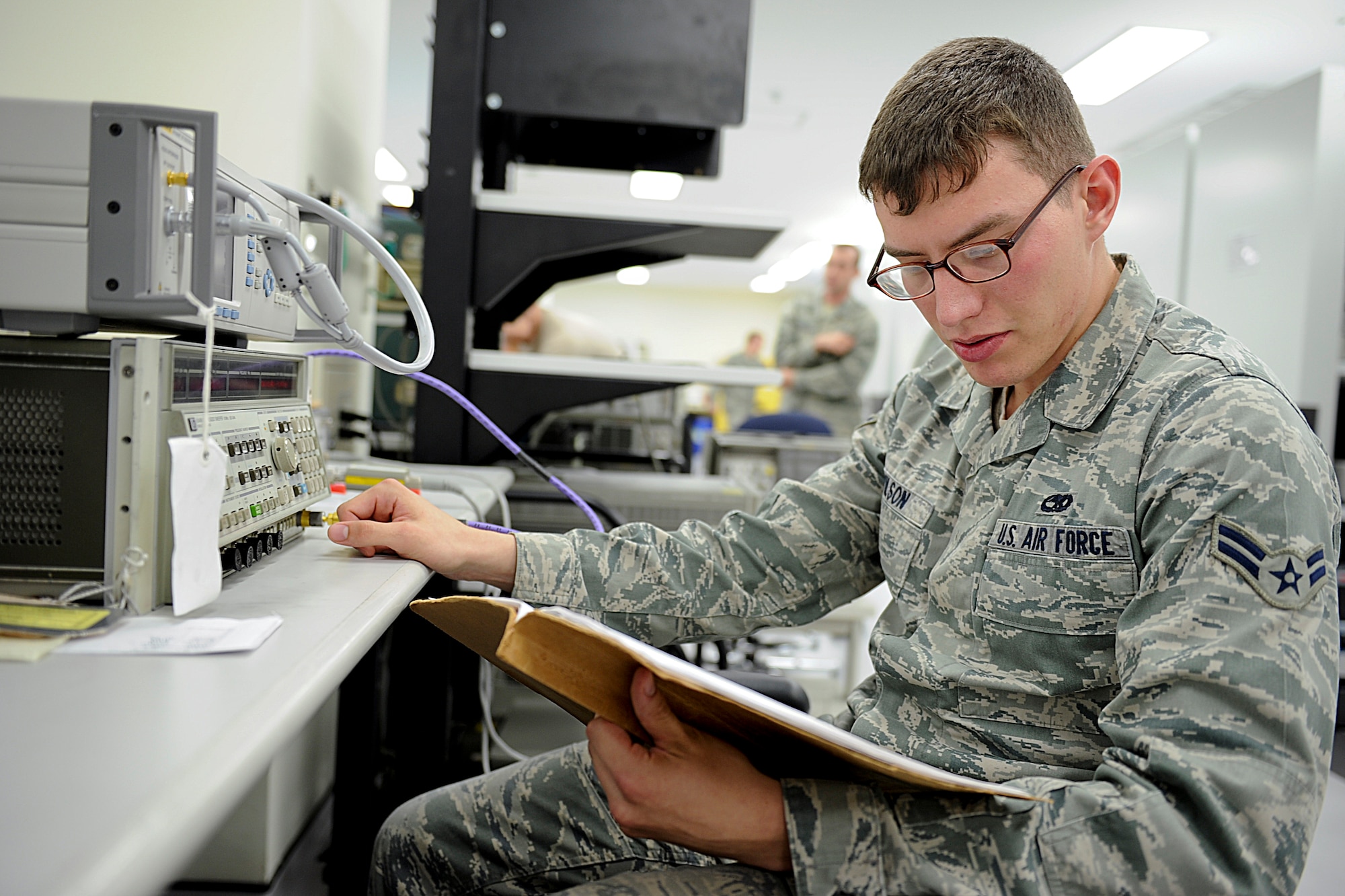 U.S. Air Force Airman 1st Class Alec Wilson, 18th Component Maintenance Squadron test measurement equipment diagnostic technician, reads technical orders while calibrating a frequency gunner on Kadena Air Base, Japan, June 12, 2012. TOs allow technicians to follow the precise measurements they need to follow in order to complete their job. (U.S. Air Force photo/ Airman 1st Class Brooke P. Beers)