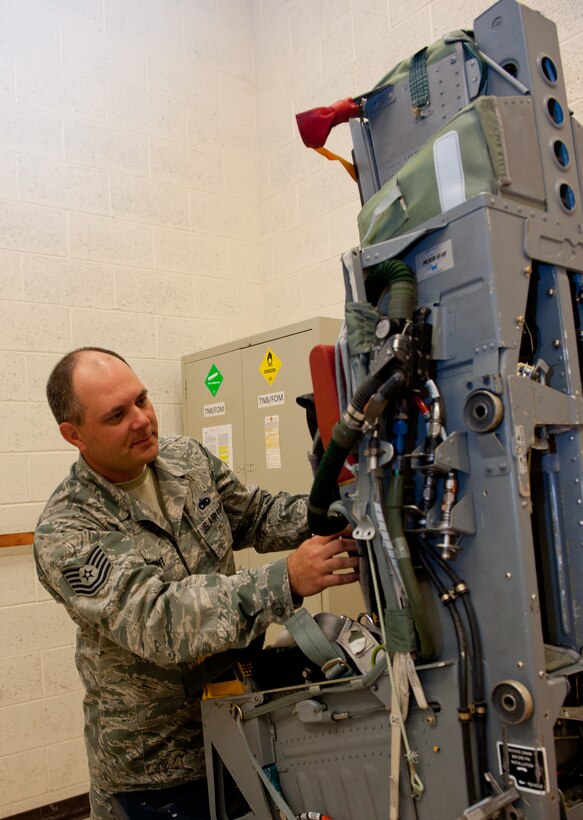 Tech. Sgt. Robert Knight, 28th Maintenance Squadron aircrew egress system technician, tests contact points for of inertia reel straps on a training Advanced Concept Ejection Seat II in the egress shop during a quality check on Ellsworth Air Force Base, S.D., June 12, 2012. In the rare event of an ejection, each B-1 aircrew members would endure 12 to 14 times the downward force of gravity. The straps ensure aircrew are properly secured to the seat to avoid severe or fatal injuries. (U.S. Air Force photo by Airman 1st Class Kate Thornton/Released)