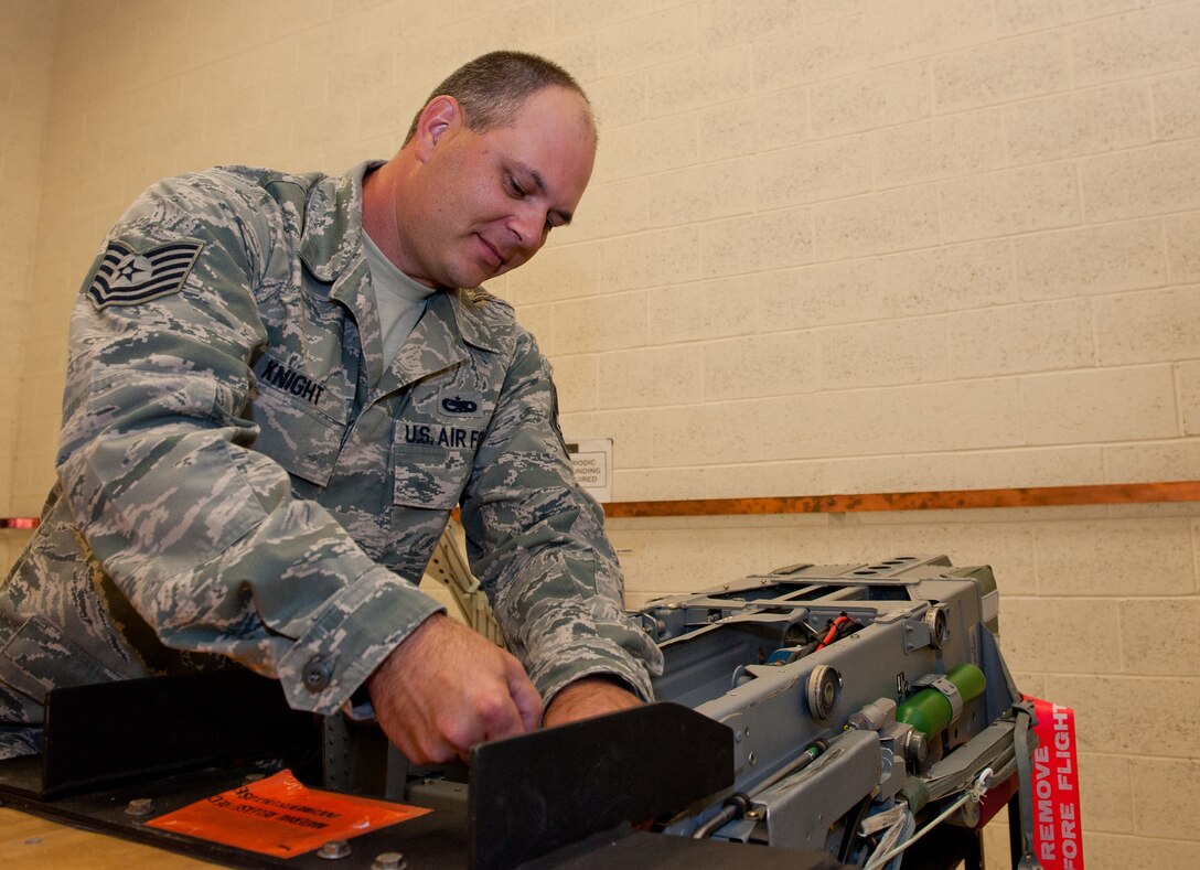 Tech. Sgt. Robert Knight, 28th Maintenance Squadron aircrew egress system technician, evaluates a harness release cartridge on a training Advanced Concept Ejection Seat II during a quality check in the egress shop on Ellsworth Air Force Base, S.D., June 12, 2012. Knight and other aircrew egress system technicians are responsible for training junior enlisted Airmen on all necessary systems and ensuring their tasks are completed correctly. (U.S. Air Force photo by Airman 1st Class Kate Thornton/Released)