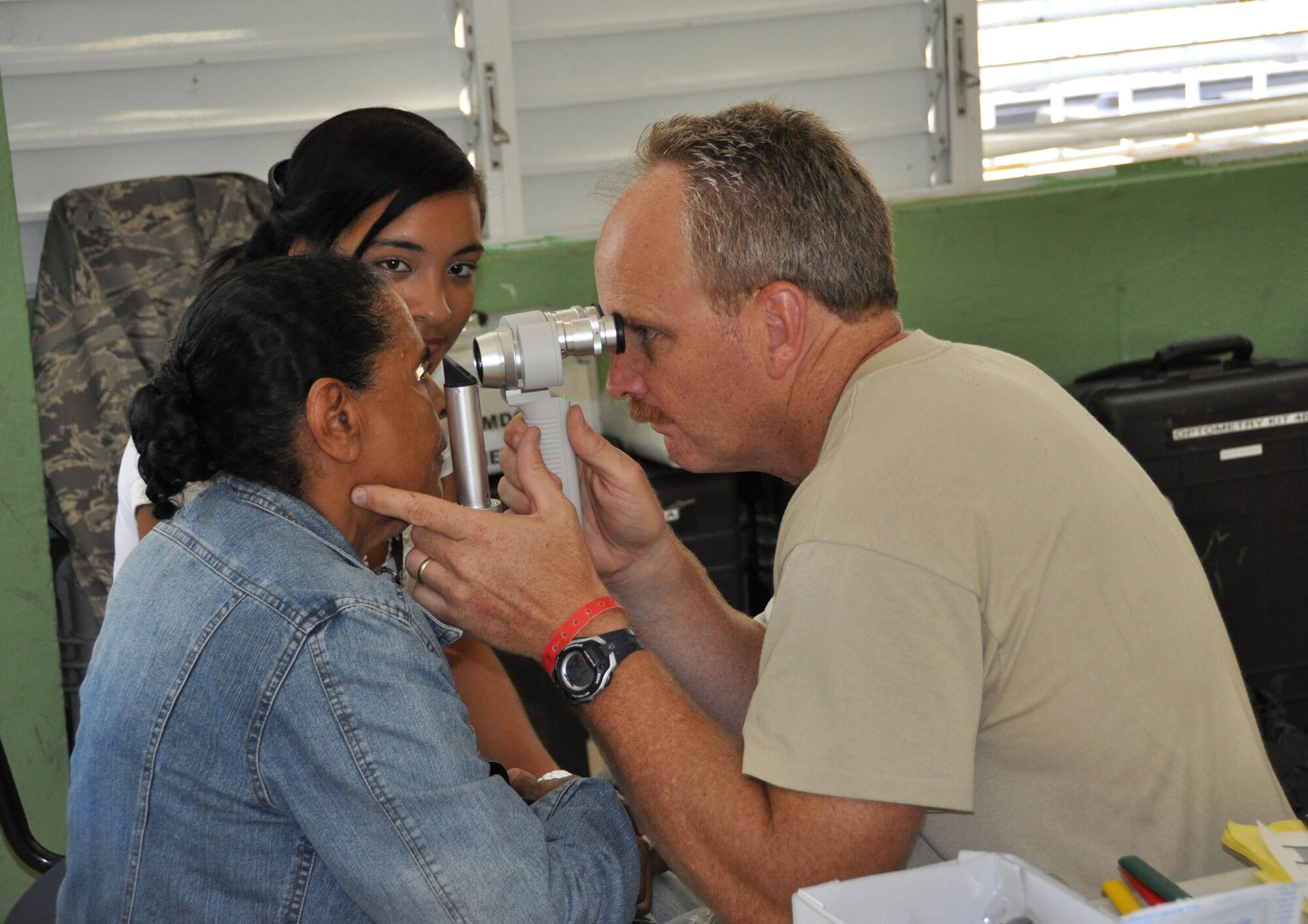 (Right) Maj. Steven Clough, 926th Aerospace Medicine Squadron optometrist, checks
the eyes of a patient. Clough was part of a 47-person U.S. team, made up
of medical, dental, optometry and pharmacy personnel, tasked to provide care
to more than 10,000 patients during a 15-day humanitarian mission to the
Dominican Republic. The optometry team saw more than 3,235 optometry
patients and handed out more than 2,380 pairs of glasses. (U.S. Air Force
Photo/Maj. Myla Abejuela)

