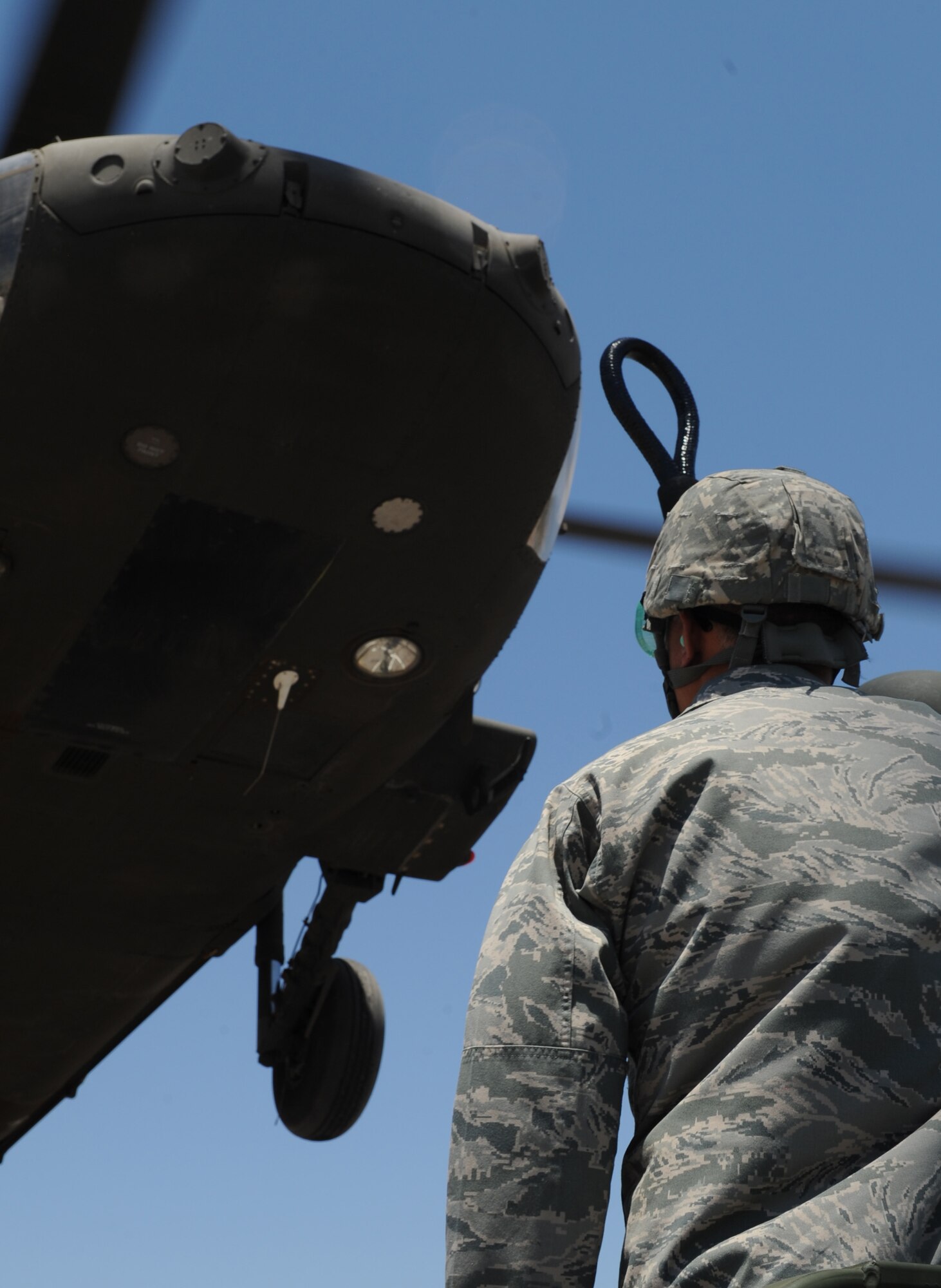 U.S. Air Force Lt. Col. Kjall Gopaul, 355th Mission Support Group deputy commander, prepares to sling load cargo to a UH-60 Black Hawk during helicopter pre-deployment training at Davis-Monthan Air Force Base, Ariz., June 7, 2012. During this training, the UH-60 carried an A-22 cargo bag and a M-1097 high mobility multipurpose wheeled vehicle. (U.S. Air Force photo by Senior Airman Brittany Dowdle/released)