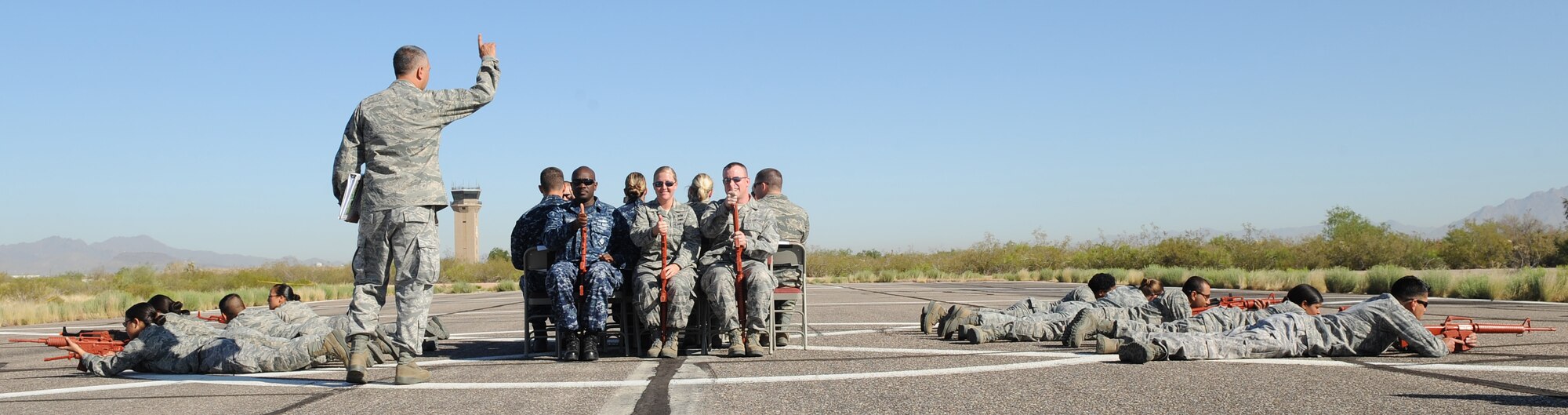 U.S. Air Force Lt. Col. Kjall Gopaul, 355th Mission Support Group deputy commander, teaches participants of the helicopter pre-deployment training how to load and unload on folding chairs, before learning on a real UH-60 Black Hawk at Davis-Monthan Air Force Base,  Ariz., June 7, 2012. This training was the first of its kind for the base. (U.S. Air Force photo by Senior Airman Brittany Dowdle/released) 