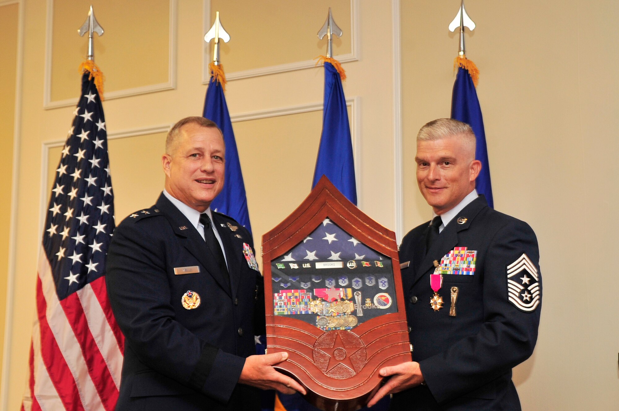 U.S. Air Force Chief Master. Sgt. Robert Brooks, 9th Air Force command chief, receives a shadow box from Maj. Gen. Lawrence Wells, 9th Air Force commander, at his retirement ceremony at Shaw Air Force Base, S.C., June 8, 2012. The shadow box contained important milestones in Brooks career, including his diamond from his duty as a first sergeant at the 21st Security Forces Squadron, Peterson AFB, C.O.(U.S. Air Force photo by Airman Nicole Sikorski/Released)