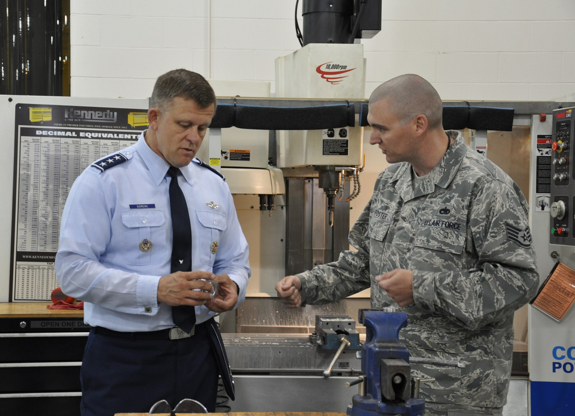 WRIGHT-PATTERSON AIR FORCE BASE, Ohio - Staff Sgt. Michael Foster, 445th Maintenance Squadron aircraft metals technician, presents Lt. Gen. Frank Gorenc, Assistant Vice Chief of Staff and Director, Air Staff, Heaquarters U.S. Air Force a "jack in the box" he created using a milling machine. The machine is used to make aircraft parts. Gen Gorenc visited members of the 445th Airlift Wing June 7. (U.S. Air Force Photo/Stacy Vaughn)