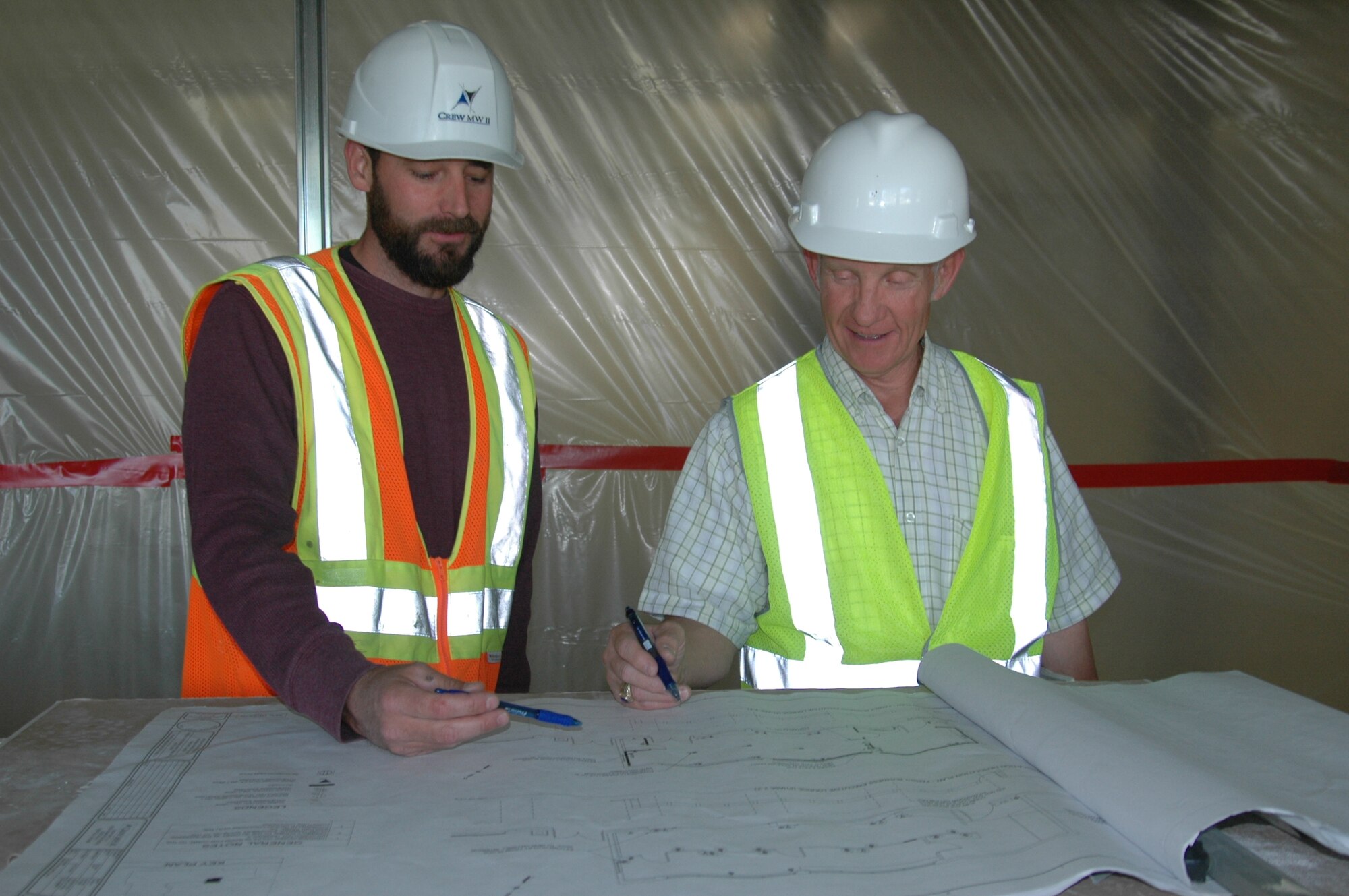 Nathan Kelly, Crew MW II contract superintendent, reviews construction plans with Edward Emmons, 60th Contracting Squadron contract specialist, May 21 at the Travis Passenger Terminal. (U.S. Air Force photo/Tyler Grimes)