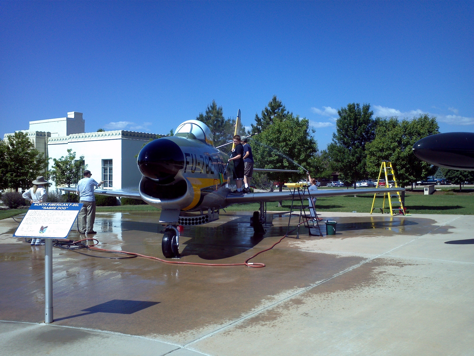 PETERSON AIR FORCE BASE, Colo. -  Adult and youth volunteers from the 21st Space Wing staff agencies kicked off the Peterson Air and Space Museum's “Adopt-A-Plane” season May 31 by washing the F-86 Sabre Dog. Through the Adopt-A-Plane program, base organizations perform periodic washings and minor maintenance on the museum's display aircraft and missiles. The 21st SW staff has adopted the F-86 since 2008. Several museum display aircraft are available for adoption. For information on “adopting” a piece of military history, contact Jeff Nash at 556-8314. (U.S. Air Force photo/Jeff Nash)