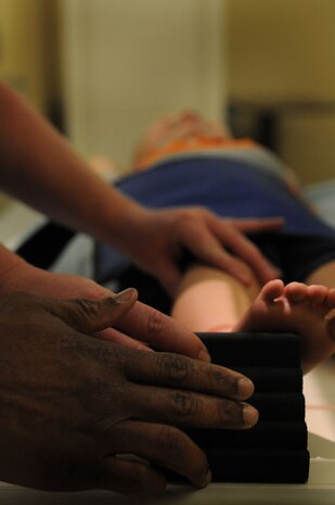 Military spouse Rachel Gordan is instructed by Orville Clarke, X-ray technician, on how to hold her three-year-old son’s foot securely against a sponge molding for an X-ray of his right ankle. Noticing swelling on her son’s ankle, Gordan brought him in to see if he had breaks or fractures. Gordan is the wife of Petty Officer 1st Class William Gordan, a hospital corpsman assigned to Naval Operational Support Center Charleston. (U.S. Navy photo/Petty Officer 1st Class Jennifer Hudson)
