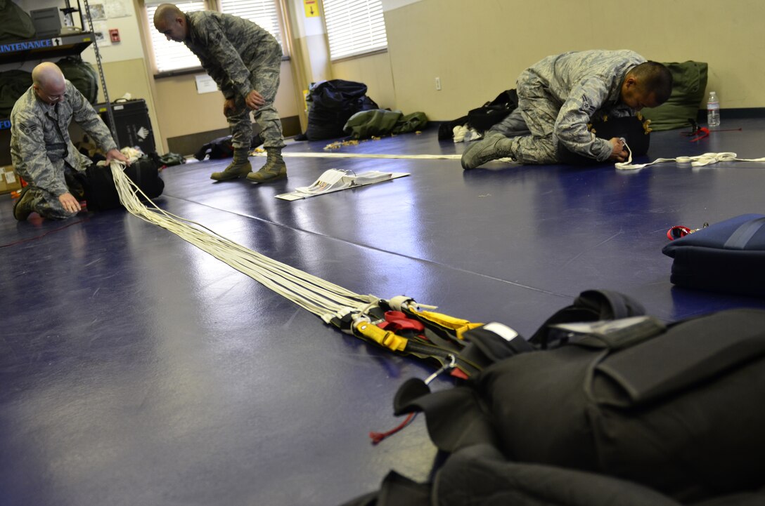 Airmen assigned to the 131st Rescue Squadron prepare and pack static line chutes June 9, 2012 at Moffett Federal Airfield, Calif.  These aircrew flight equipment specialists are staying proficient in their career fields while also preparing to attend SERE (search escape survival evasion) school. (Air National Guard photo by Airman 1st Class John Pharr)