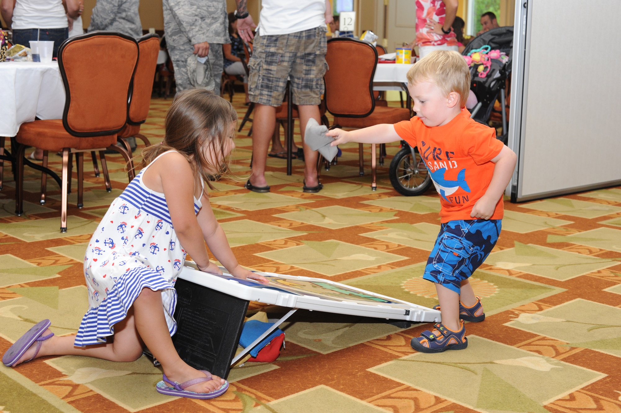 Sophia Gonzales, 4, daughter of Tech. Sgt. Santiago Gonzales, 19th Aircraft Maintenance Squadron at Little Rock Air Force Base, Ark., watches as her nephew Micah, 2, plays bean bag toss while at the Soundside Club at Hurlburt Field, Fla., June 9, 2012. Children had an opportunity to play games and bounce in a large bounce castle within the club. (U.S. Air Force photo / Senior Airman Joe McFadden)(RELEASED)