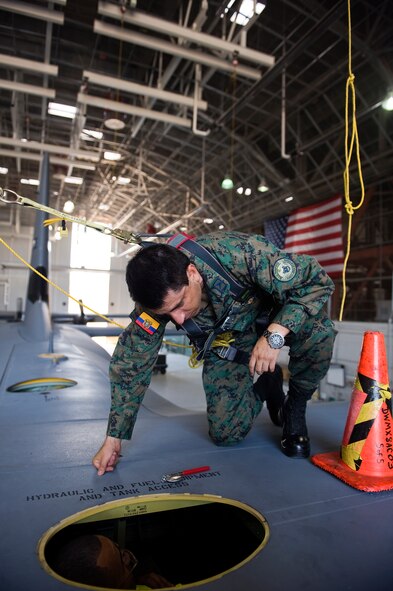 Ecuadorian air force Maj. Celio Puga talks to Senior Airman Marcos Morales, 317th Maintenace Squadron June 4, 2012, while he’s inside a dry dock of a C-130J at Dyess Air Force Base, Texas. Puga has been stationed at Dyess for more than a year as part of a program that allows foreign servicemembers the opportunity to learn from the U.S. Air Force and vice verse. (U.S. Air Force photo by Airman 1st Class Damon Kasberg /Released)