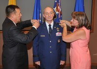 KIRTLAND AFB, N.M. – Retired Maj. Gen. Robert Smolen, left, and Tanya Harencak, right, pin the second star on Maj. Gen. Garrett Harencak, Air Force Nuclear Weapons Center commander, in a June 1 ceremony at the AFNWC. (Photo by Todd Berenger)