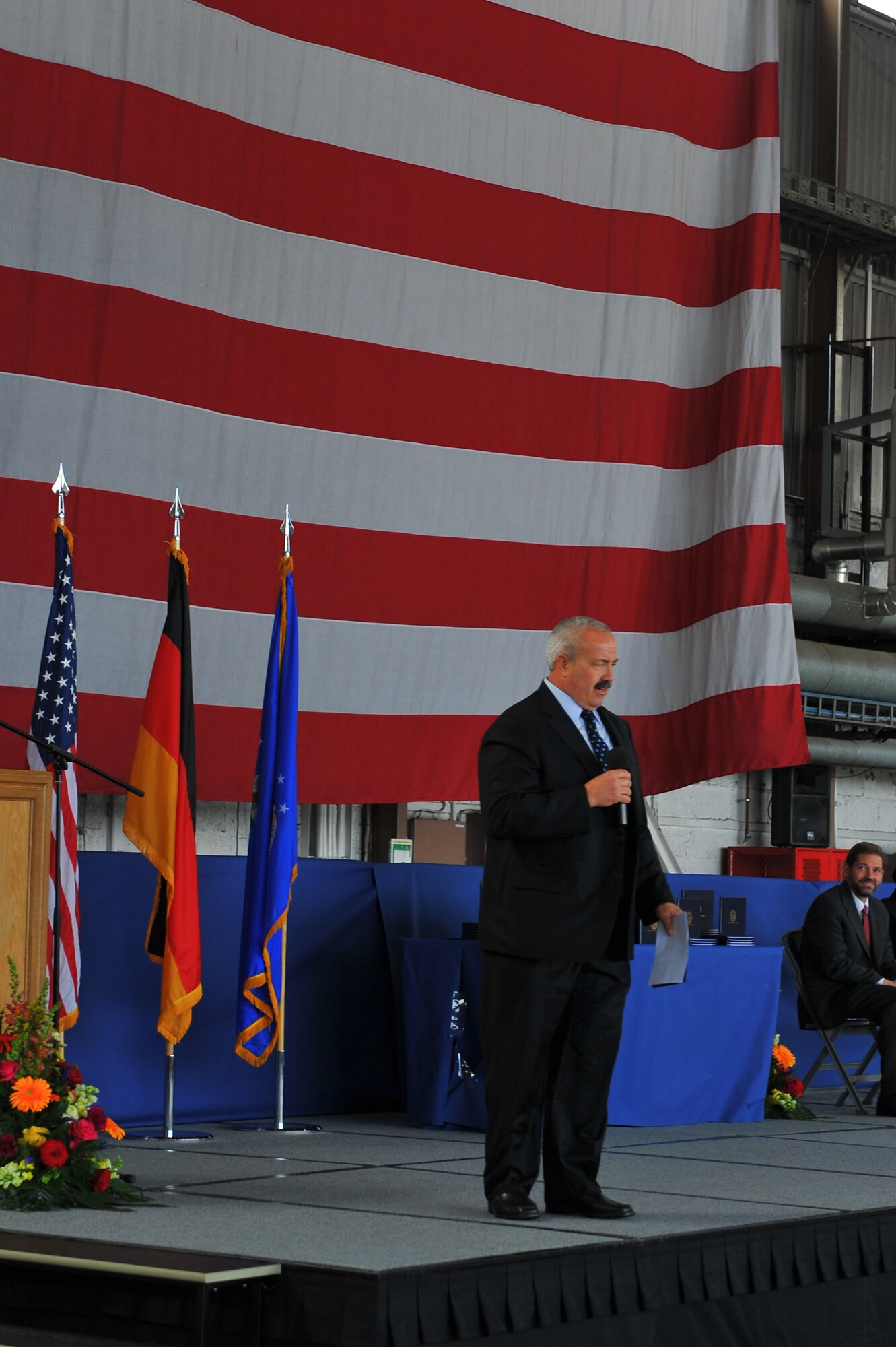 SPANGDAHLEM AIR BASE, Germany – Guest speaker, Michael Laue, BHS sports coordinator, speaks to Bitburg High School graduates about preparing and executing their goals and plans for their futures during their graduating ceremony inside Hangar 1 here June 9. The class of 2012 consisted of 54 students. More than 300 family members and guests attended the ceremony to celebrate the completion of their high school education. (U.S. Air Force photo by Airman 1st Class Dillon Davis/Released)