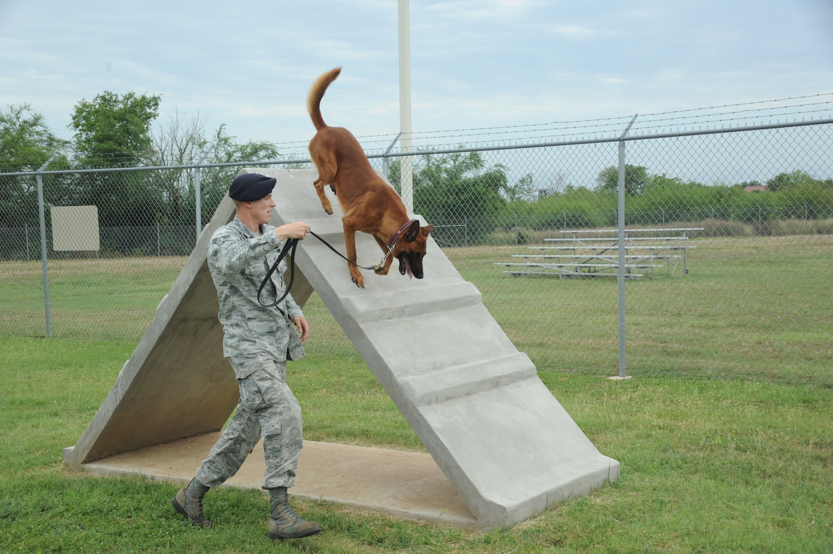 Senior Airman Clinton Patton, 902nd Security Forces Squadron military working dog handler, runs his military working dog Ccharles through the obstacle course at the wmd kennel at Joint Base San Antonio-Randolph, Texas, June 7. (U.S. Air Force photo by Rich McFadden) 