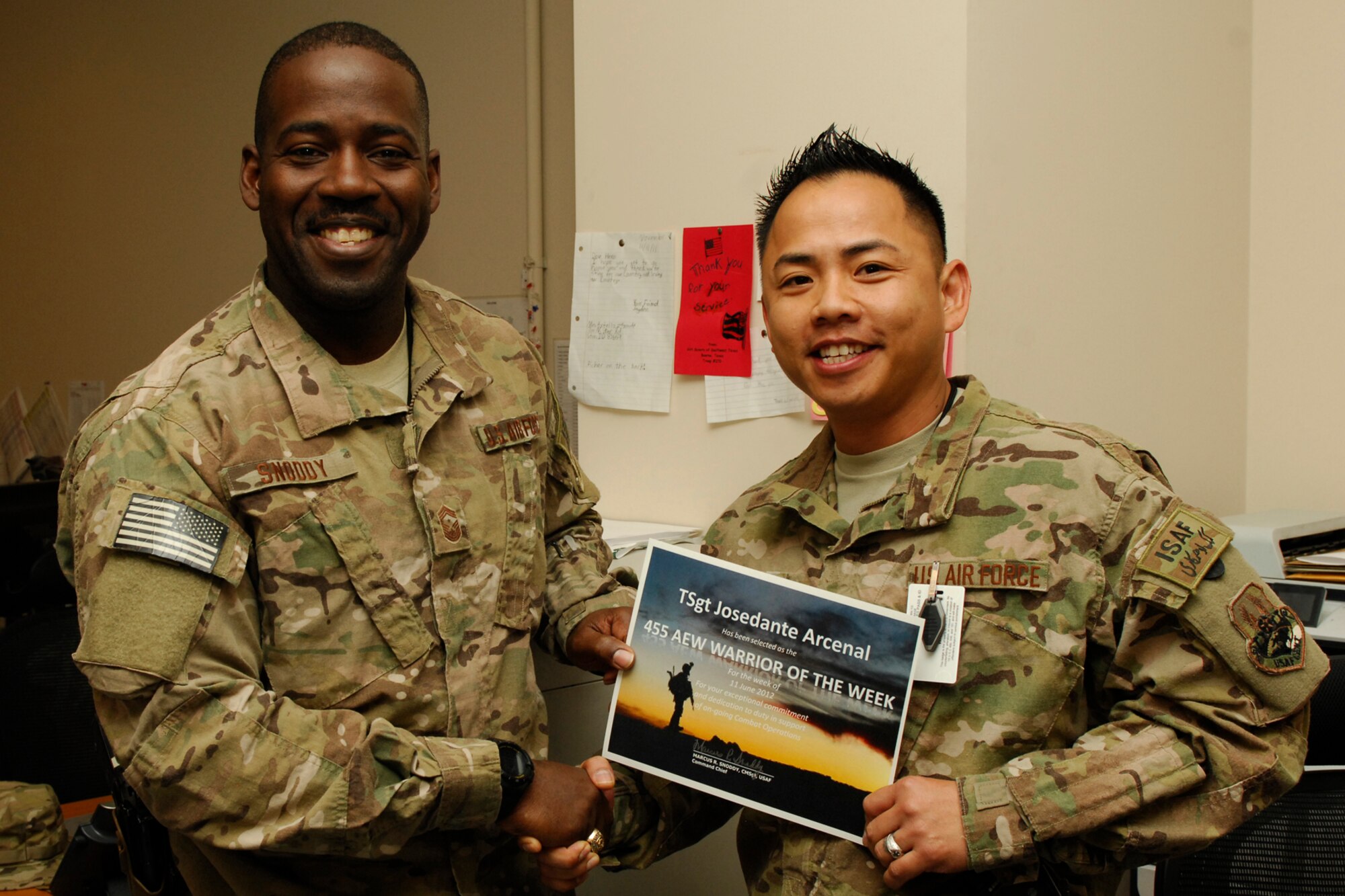 Chief Master Sgt. Marcus Snoddy, 455th Air Expeditionary Wing command chief, presents the Warrior of the Week award to Tech. Sgt. JoseDante Arcenal, 455th Personnel Support for Contingency Operations NCOIC at Bagram Airfield, Afghanistan, June 12, 2012. Arcenal completed his Professional Military Education “Course 14” online in four weeks, surpassing the allocated time by 11 months.  His ingenuity was evident when he developed of a PERSCO patch which is currently being processed for approval for all Air Force personnel in Afghanistan. (U.S. Air Force photo/Staff Sgt. Jeff Nevison)