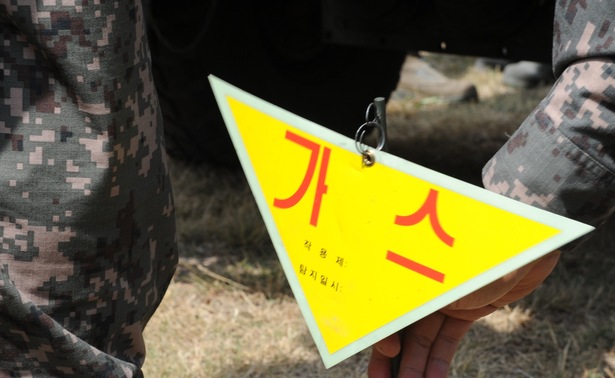A warning sign is retrieved after being ejected from a decontamination vehicle used by Republic of Korea Air Force members during training with Pacific Air Forces bases June 8, 2012, at Kunsan Air Base, Republic of Korea. The capability to detect contaminants without leaving a vehicle is a unique one for the ROKAF. (U.S. Air Force photo/Senior Airman Brigitte N. Brantley)