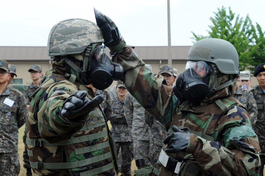 Staff Sgt. Ashley Bartlett, right, 8th Civil Engineer Squadron, decontaminates Master Sgt. Jeffrey Randall, 8th CES, during a demonstration of a contamination control area for Republic of Korea Air Force members June 8, 2012, at Kunsan Air Base, Republic of Korea. Because U.S. and South Korean forces would work together during a chemical, biological, radiological or nuclear attack, being familiar with the other’s equipment and procedures is important. (U.S. Air Force photo/Senior Airman Brigitte N. Brantley)
