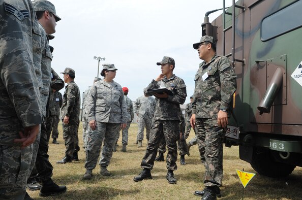 U.S. and Republic of Korea Air Force members talk about the differences in equipment during joint training June 8, 2012, at Kunsan Air Base, Republic of Korea. The goal of the training was to become more familiar with how each group would respond during a chemical, biological, radiological or nuclear attack. (U.S. Air Force photo/Senior Airman Brigitte N. Brantley)
