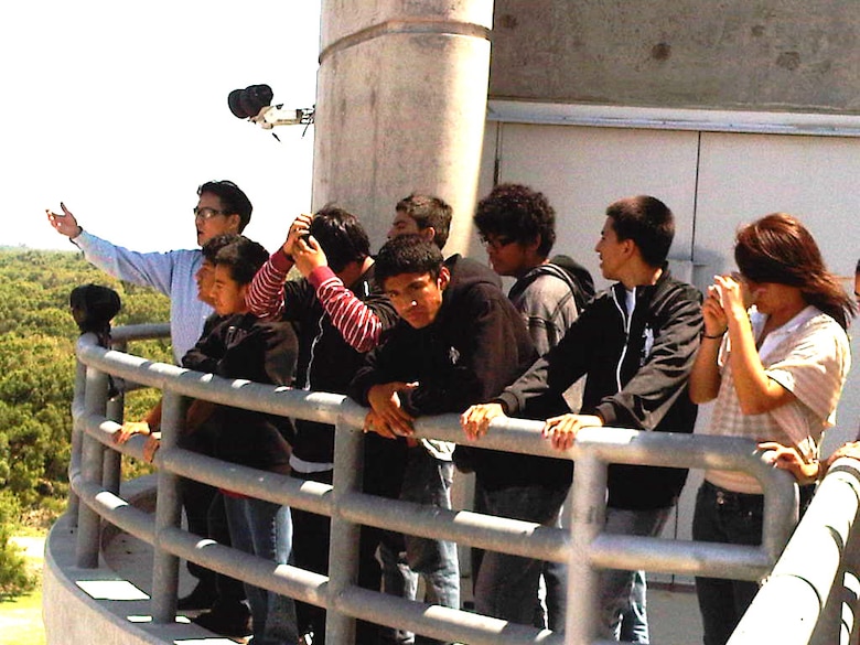 Ninth grade students from Roosevelt High's Math, Science and Technology Magnet Academy stand atop the Prado Dam intake tower overlooking the wildlife basin as, Michael Siu, the supervisory engineer at Prado, explains the dam's benefits.