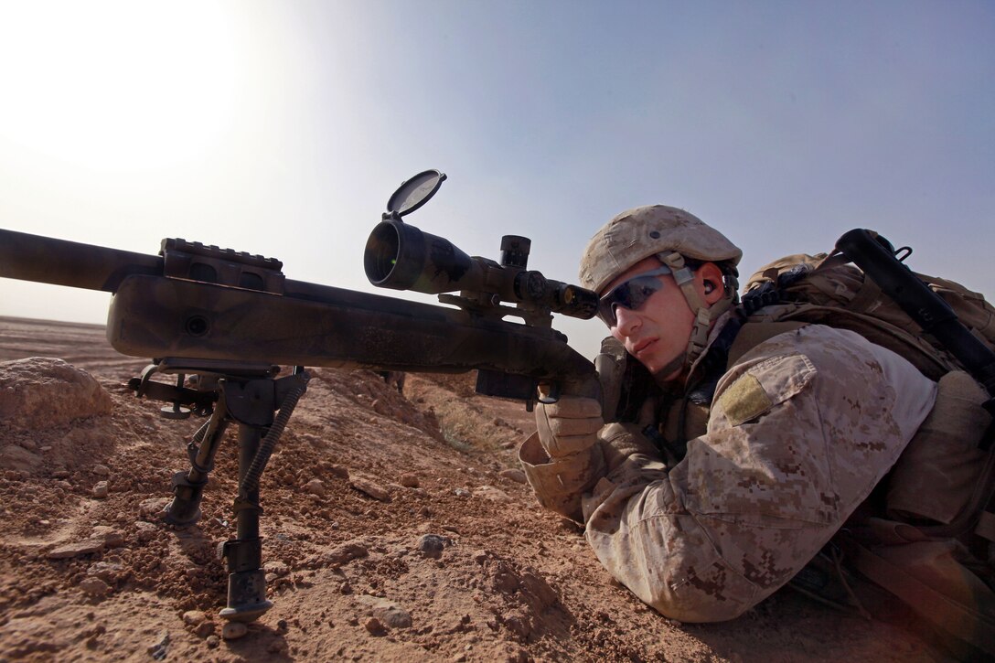 U.S. Marine Corps Sgt. Brian Matthews looks through his weapon's scope for activity while providing security for Marines and Afghan troops as they board CH-53D Sea Stallions helicopters after conducting their third raid of the day in Afghanistan's Helmand province, June 4, 2012. Matthews, a sniper, is assigned to the 2nd Battalion, 9th Marine Regiment.