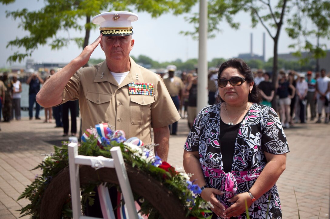 Lt. Gen. Steven A. Hummer, commander of Marine Forces Reserve and Marine Forces North, and Sandra Mandez-Ruiz, a Gold Star family member, listen to the playing of taps at a wreath laying ceremony at traveling Vietnam War Memorial Wall at Voinovich Park here June 12. Voinovich Park is one of the sites of displays available for public during the Marine Week Cleveland. Along with the wall, Marine Corps vehicles, aircraft and equipment will be available for viewing at Public Square, Voinovich Park, Gateway Plaza and Rock and Roll Hall of Fame. Marine Week Cleveland celebrates community, country and the Corps. More than 750 Marines journeyed to Cleveland for the event, which runs through June 17. Ohio has more than 9,000 active and reserve Marines, making it one of the top-five producers of Marines.