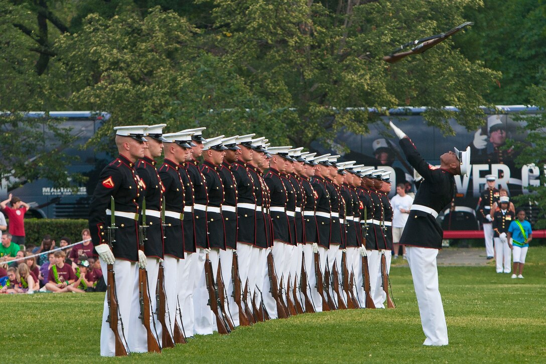 Cpl. Carlton Williams, Marine Corps Silent Drill Platoon rifle inspector, executes a rifle throw during a Tuesday Sunset Parade at the Marine Corps War Memorial in Arlington, Va., June 12.
