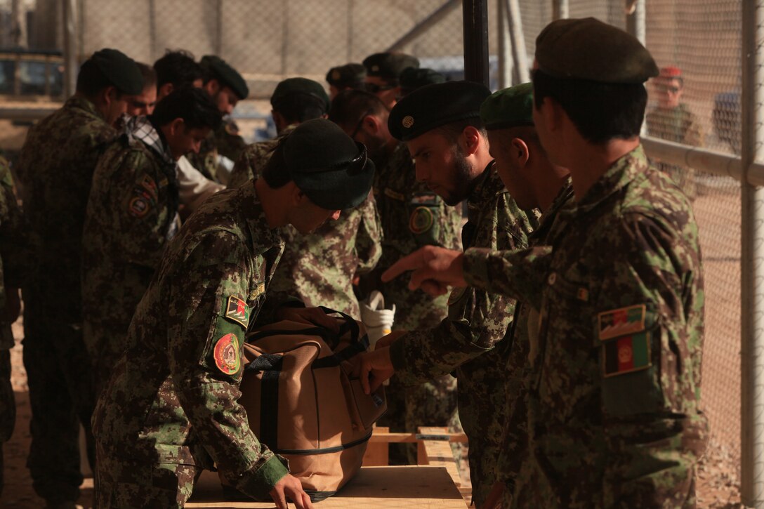 Afghan soldiers with the Afghan national Army 215th Corps have their luggage inspected before going on leave, June 6. Until recently, all leave for the Afghan National Army's 215th Corps were administratively handled by the Marines of the Embedded Training Team here. As the transition of security takes place, the administration and logistics of some much-needed time off is taken care of by the Afghans as well.