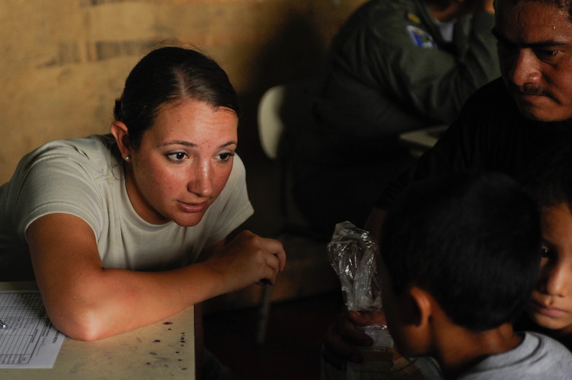 Senior Airman Maria Abello listens closely to an El Salvadoran child as he explains his ailments during a joint Medical Readiness Training Exercise. Participating as a translator, Abello along with other Joint Task Force-Bravo members provided care to 776 local patients in the municipalities of El Castano and Rancho San Marcos, El Salvador, during a two-day joint Medical Readiness Training Exercise in partner with the country’s Ministry of Health and military. (U.S. Air Force photo/1st Lt. Christopher Diaz)
