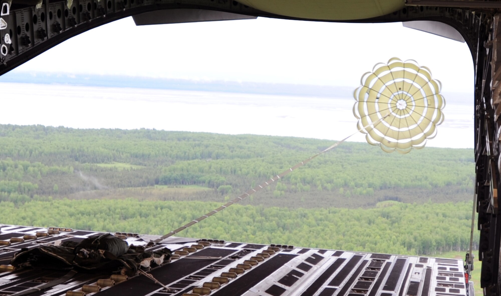 A drogue parachute connected to a 3,200-pound heavy aerial delivery platform deploys behind a 535th Airlift Squadron C-17 Globemaster III aircraft from Joint Base Pearl Harbor-Hickam, Hawaii, June 13 as part of the RED FLAG-Alaska military exercise. RED FLAG-Alaska is one of the largest international air-combat employment exercises in the world and is designed to test the specific capabilities of the military units that take part in the exercise and increase their chance of survival during actual combat. (U.S. Air Force photo by Capt. Ben Sakrisson)