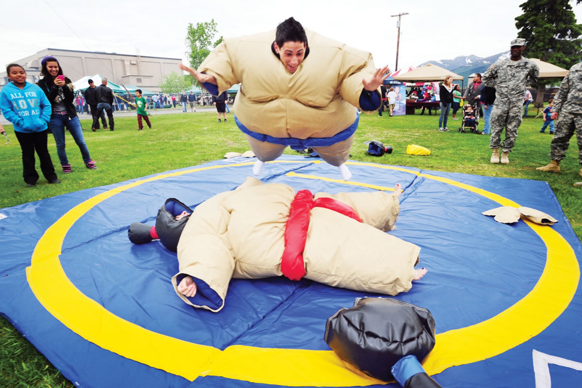 Victor Perez Jr. fl ies through the air before bodyslamming his mom, Ivette Perez, in a padded Sumo wrestling outfi t during the Military Appreciation Day at JBER June 8. The duo are dependents of Sgt. 1st Class Victor Perez of the 6t h Engineer Battalion (Combat) (Airborne). (U.S. Air Force photos/Justin Connaher)