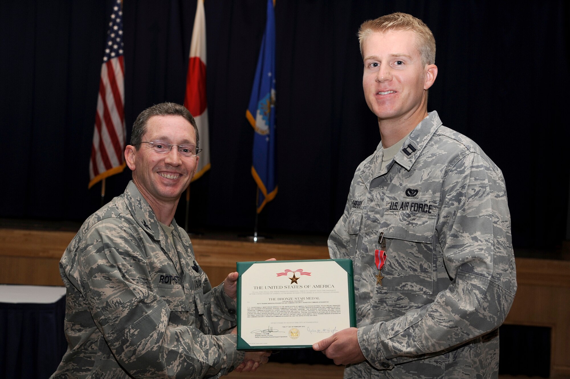 U.S. Air Force Col. Michael D. Rothstein, left, 35th Fighter Wing commander, presents the Bronze Star to Capt. Reid Touchberry, 35th Civil Engineer Squadron chief of plans and programming, during an official ceremony at Misawa Air Base, Japan, June 13, 2012. Touchberry received the Bronze Star for his superior leadership and mentorship provided to the Afghan National Police during his recent deployment to Afghanistan. (U.S. Air Force photo by Tech. Sgt. Marie Brown)