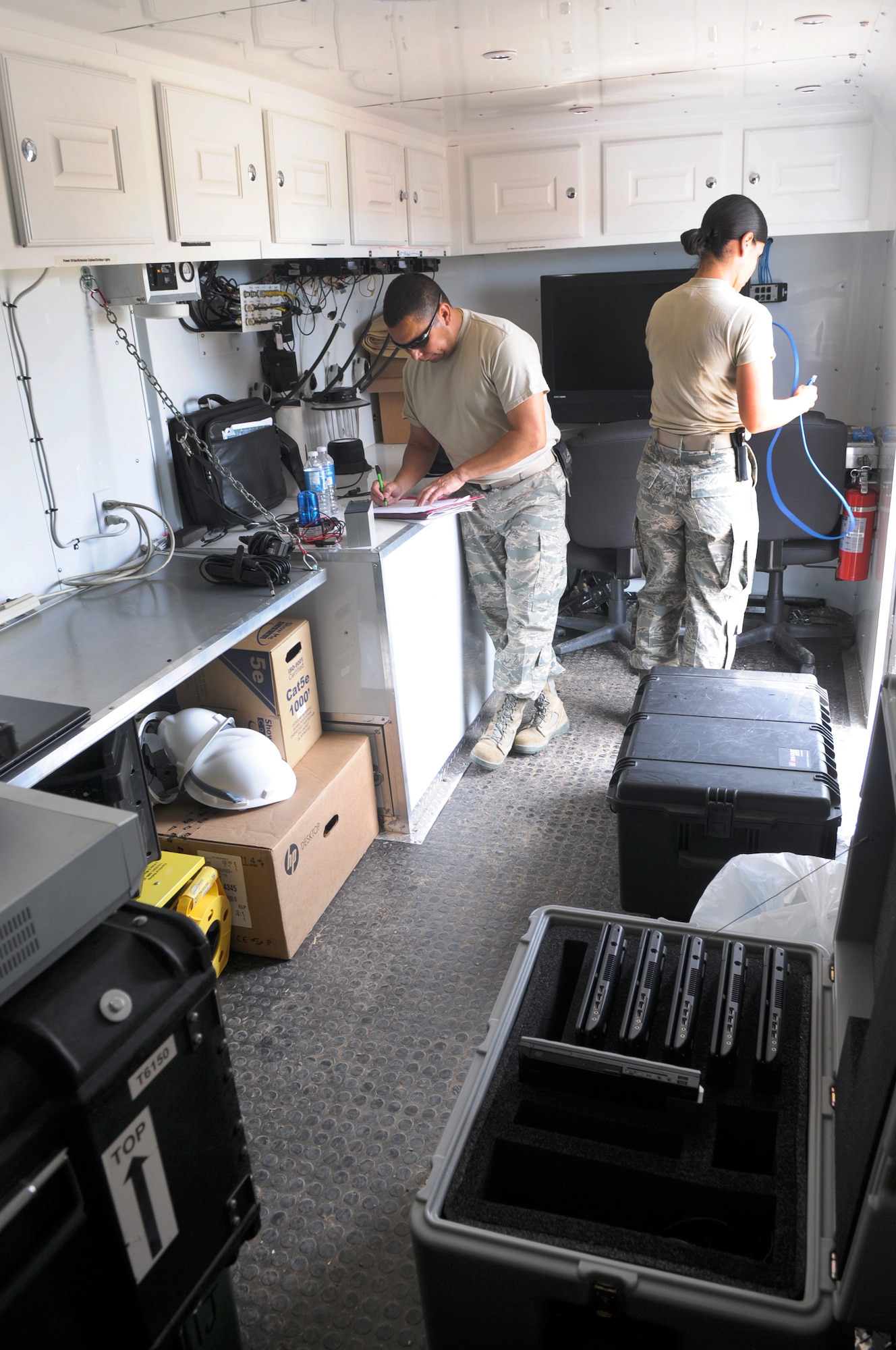 Master Sgt. Mark Martinez and Staff Sgt. Marie Sarabi, members of the 149th Communications Flight, a subcomponent of the Texas Air National Guard's 149th Fighter Wing, working in a mobile Texas Interoperability Communications Package (TICP) at Yankee Range, in McMullen County, during the Texas Red Flag exercise, on June 1, 2012. (Air National Guard photo by Senior Master Sgt. Mike Arellano / Released)