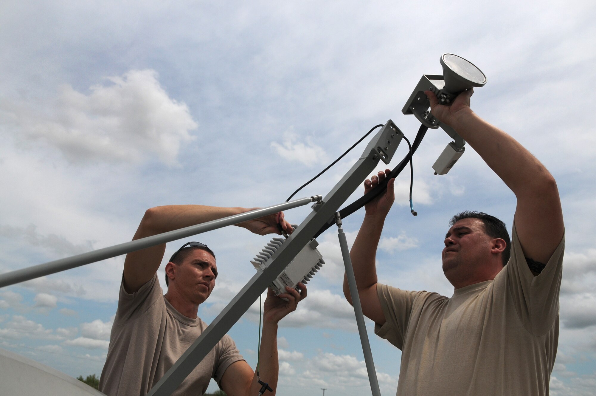 Staff Sgts. Joshua Cash (left) and Joseph Dawson (right), members of the 149th Communications Flight, a subcomponent of the Texas Air National Guard's 149th Fighter Wing, install a TRACSTAR satellite uplink device, which provided mobile communications for the Texas Red Flag exercise at Yankee Range, in McMullen County, on June 1, 2012. (Air National Guard photo by Senior Master Sgt. Mike Arellano / Released)