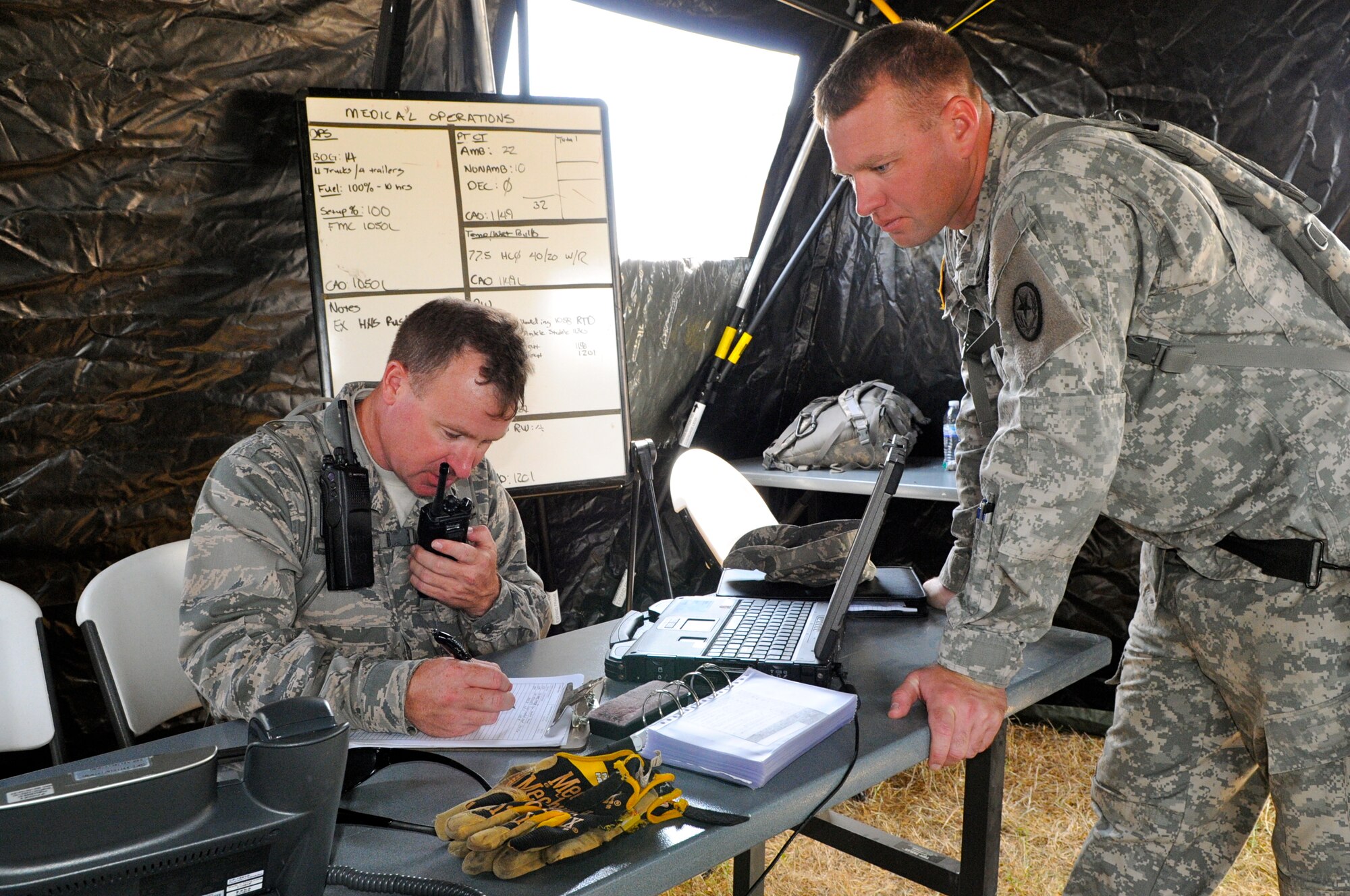 Air Force Capt. Wayne Hill (left), a medical plans and operations officer, coordinates activities as the officer-in-charge of the air medical operations with Army Staff Sgt. Kevin Creasy, noncommissioned officer-in-charge of 6 CERF-P tactical operations center, during an emergency preparedness exercise in Austin, Texas, on Apr. 26, 2012. (Air National Guard photo by Senior Master Sgt. Mike Arellano / Released)