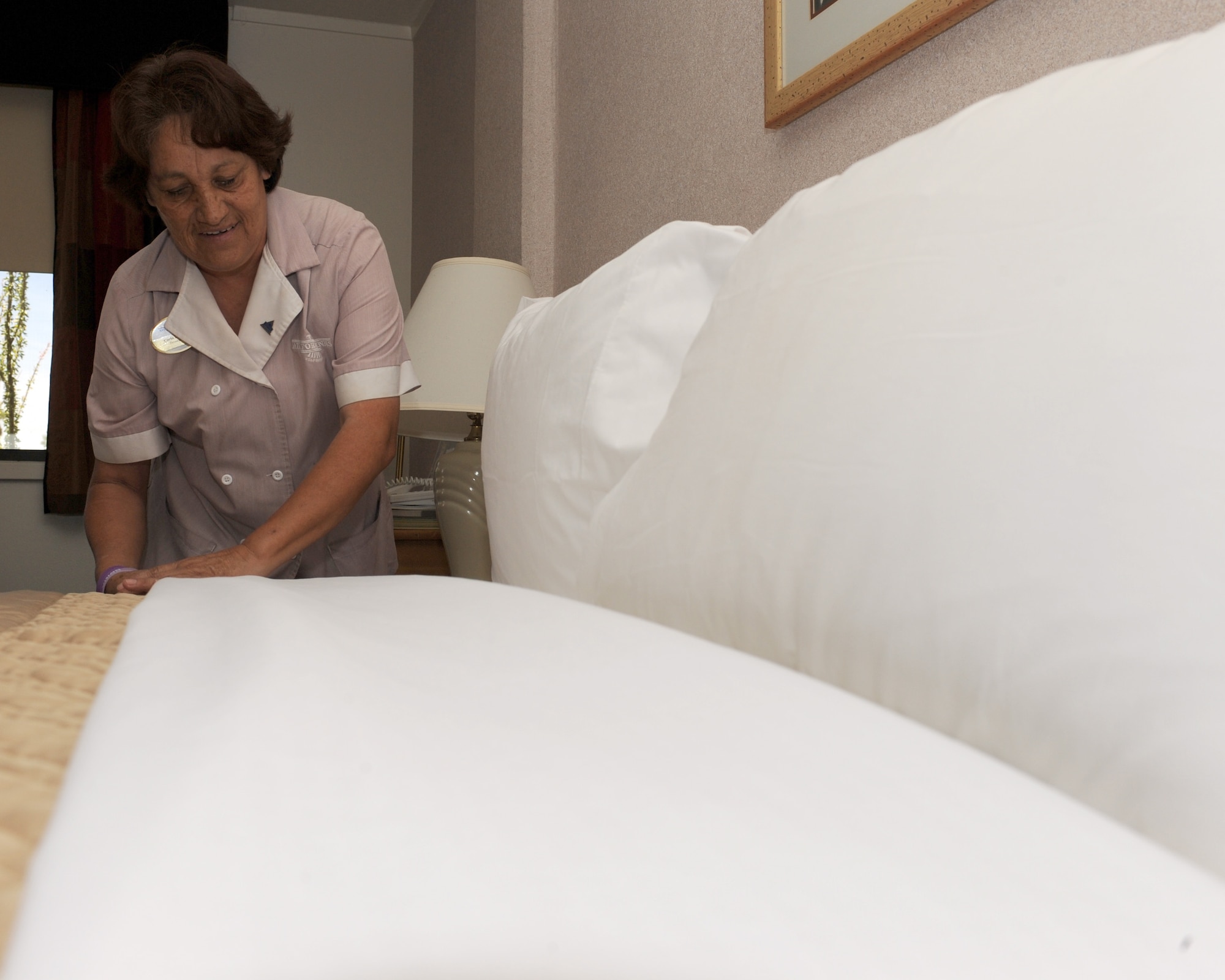 Carla Leon, housekeeper, folds down a bed set in a guest room in the Air Force Inn on Davis-Monthan Air Force Base, Ariz., June 12, 2012. The housekeepers at the inn currently manage 295 rooms including distinguished visitors’ rooms. (U.S. Air Force photo by Airman 1st Class Timothy D. Moore/Released)