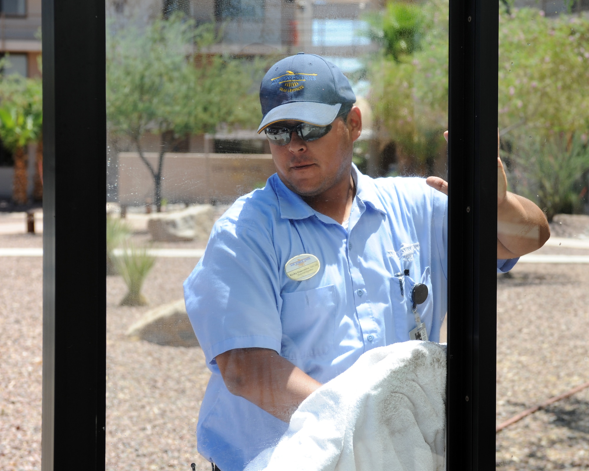 Ricardo Guerrero, laborer, washes the window of the bus stop in front of the Air Force Inn on Davis-Monthan Air Force Base, Ariz., June 12, 2012. Guerrero was named the 2011 Laborer of the Year. (U.S. Air Force photo by Airman 1st Class Timothy D. Moore/Released)