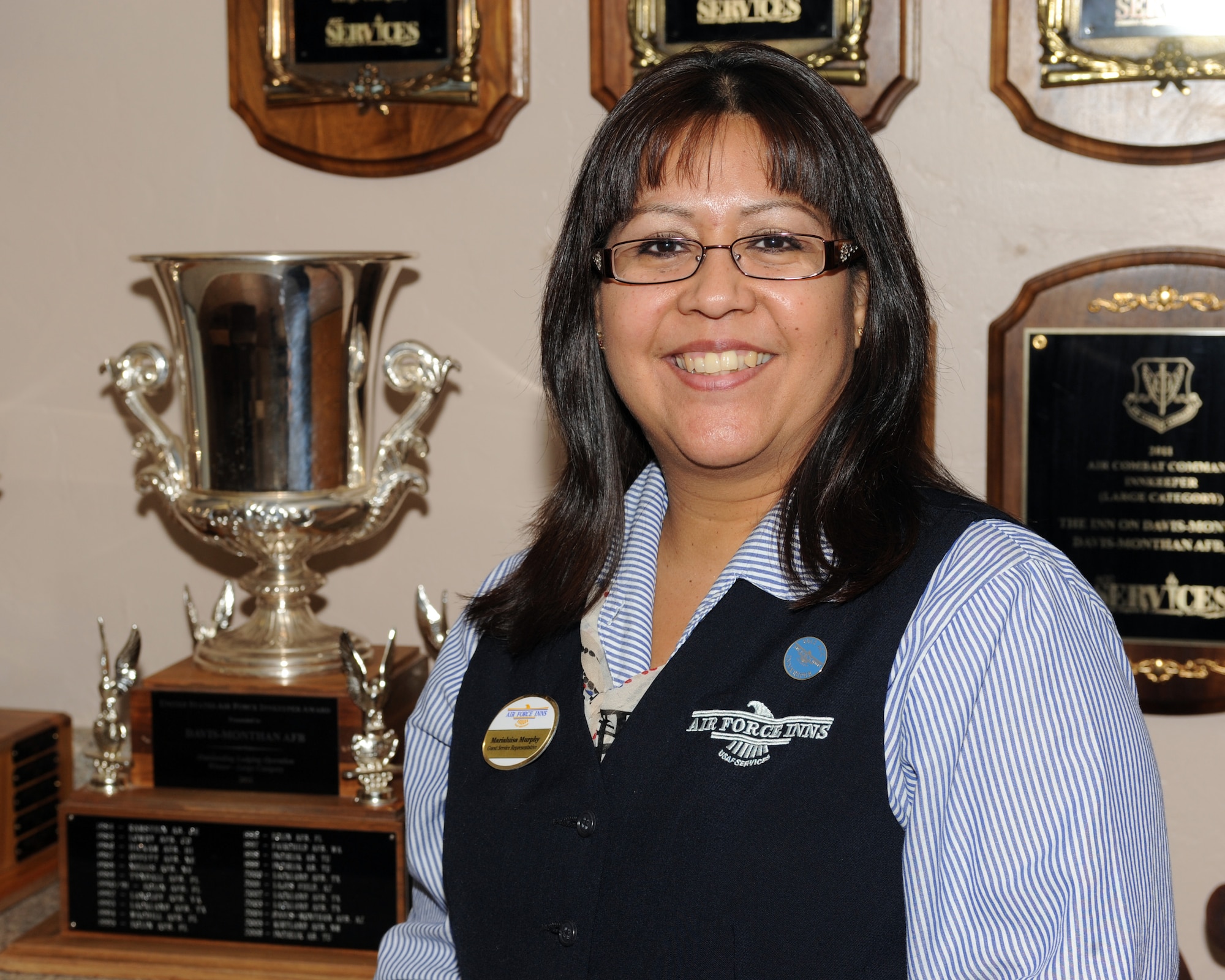 Maria Luisa Murphy, front desk representative, stands in front of the awards won by the Air Force Inn including the trophy for Best Lodging Operation on Davis-Monthan Air Force Base, Ariz., June 12, 2012. The inn has won the Best Lodging Operation seven out of the past nine years. (U.S. Air Force photo by Airman 1st Class Timothy D. Moore/Released)