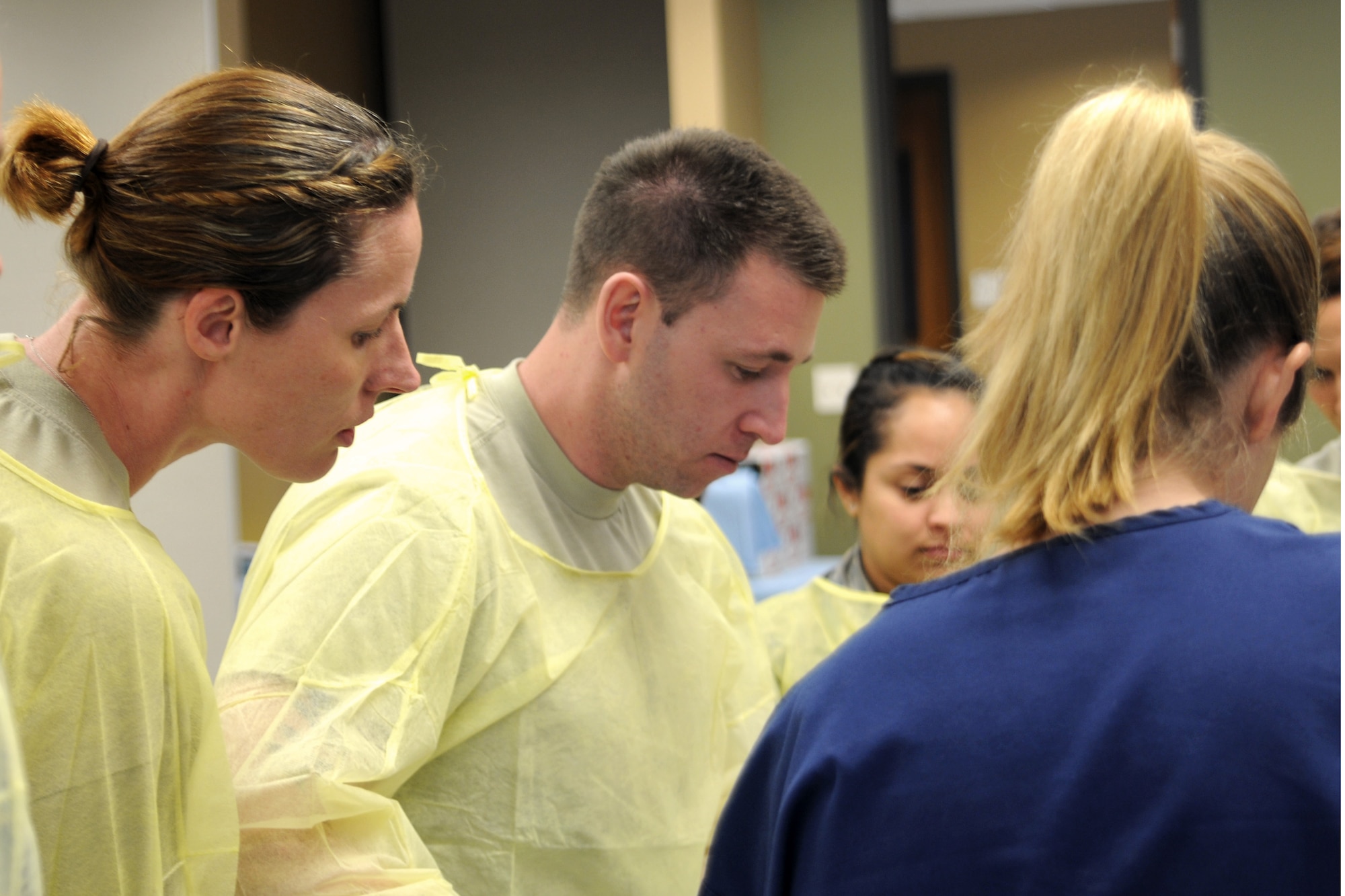 Tech. Sgt. Sarah Wilcox and 2nd Lt. Michael Fusaro, both with the Texas Air National Guard's 149th Medical Group, look on as Candice Thompson, a senior paramedic, demonstrates a medical procedure during a training exercise at the Bulverde Spring Branch Emergency Medical Service (EMS) facility, in Spring Branch, Texas, on Apr. 22, 2012. (Air National Guard photo by Staff Sgt. Phil Fountain / Released)