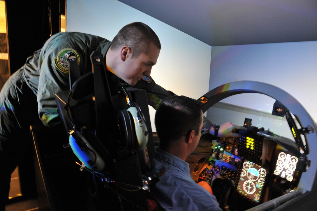 2nd Lt. Eric Goral 469th Flying Training Squadron, shows Jeff McNight, local civilian pilot, a flight simulator used to train pilots in the Euro-NATO Joint Jet Pilot Training program during the Civilian Fly-in event June 9, 2012. The main purpose of the event was based on a common denominator both civilian and military pilots share—flight safety and avoidance of mid-air collisions. (U.S. Air Force photo/ Senior Airman Adawn Kelsey)