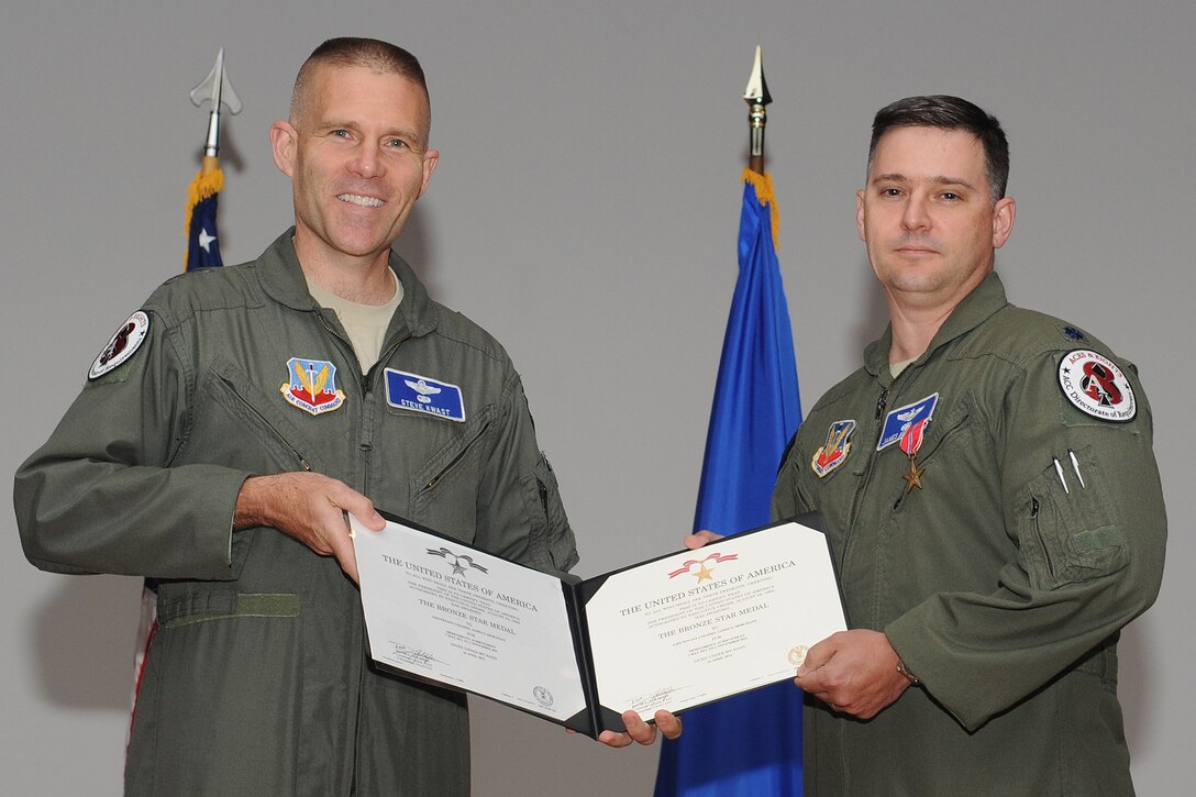U.S. Air Force Lt. Col. James Merchant (right), Air Combat Command deputy chief irregular warfare division, holds his decoration paper after receiving the Bronze Star Medal from Maj. Gen. Steven Kwast, ACC director of requirements, during an awards ceremony at Langley Air Force Base, Va., June 13, 2012. The Bronze Star Medal, a United States Armed Forces individual military decoration, may be awarded for bravery, acts of merit or meritorious service, and is the fourth-highest combat award within the U.S. Armed Forces, as well as the ninth highest military award. (U.S. Air Force photo by Airman 1st Class Racheal Watson/Released)