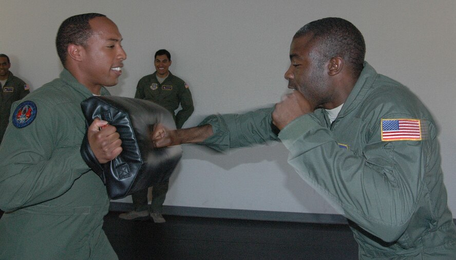 Senior Airman Davey Grimes, left, and Senior Airman Tyrone Stewart, 60th Security Forces Squadron Phoenix Raven Airmen, practice ground combat techniques Tuesday in the Phoenix Raven training center. (U.S. Air Force photo/Tyler Grimes)