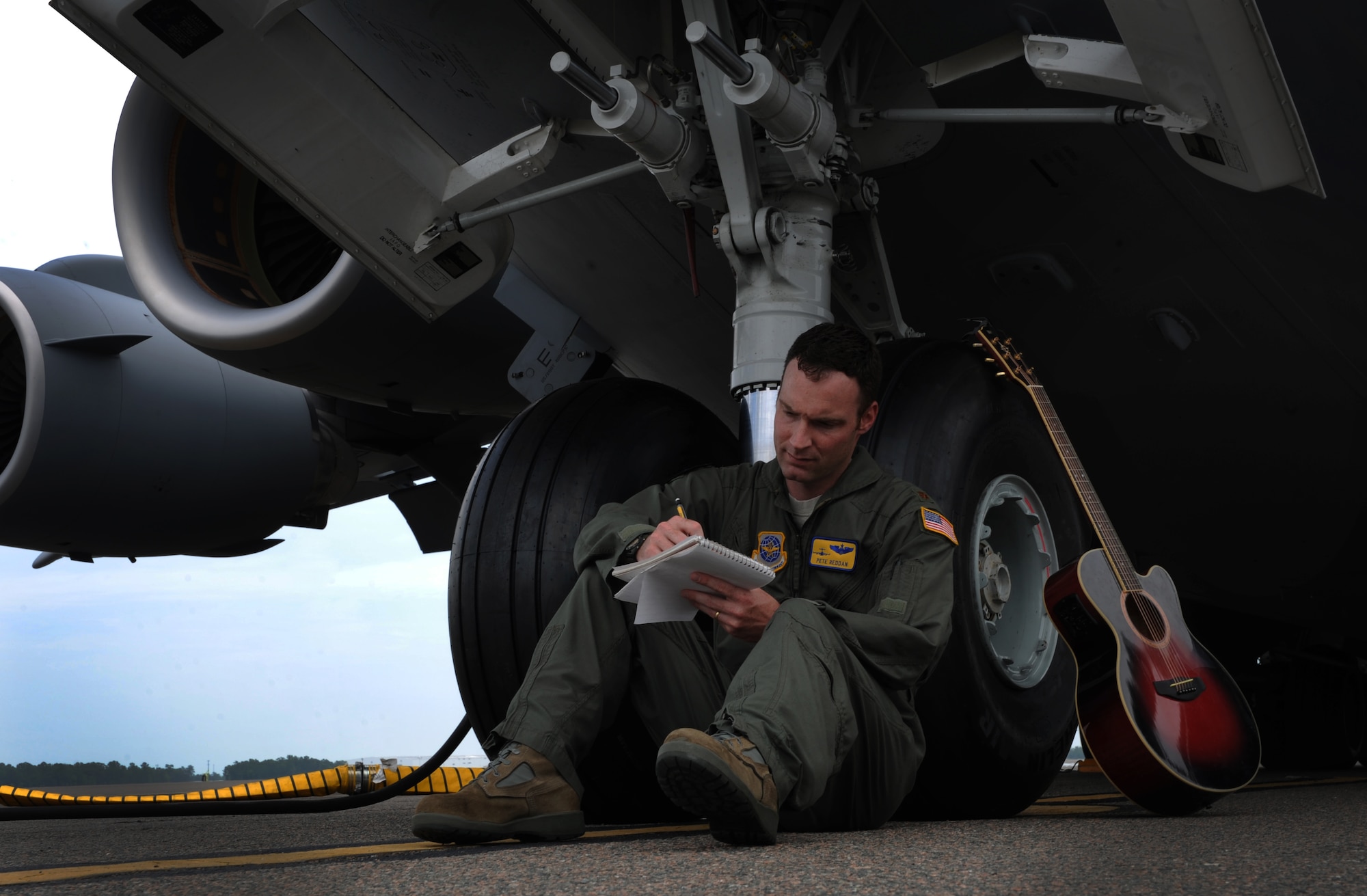 Major Pete Reddan, 437th Airlift Wing pilot, writes a song while leaning on the front tires of a C-17 Globemaster III on Joint Base Charleston, S.C.  June 13, 2012. Reddan's military inspired tune, "Off to War", was recently recorded by Nashville recording artist, Brad Anderson. The song was inspired by his experiences during deployments, as well as the experiences of the men and women Reddan serves with. (U.S. Air Force photo/Airman 1st Class Ashlee Galloway)

