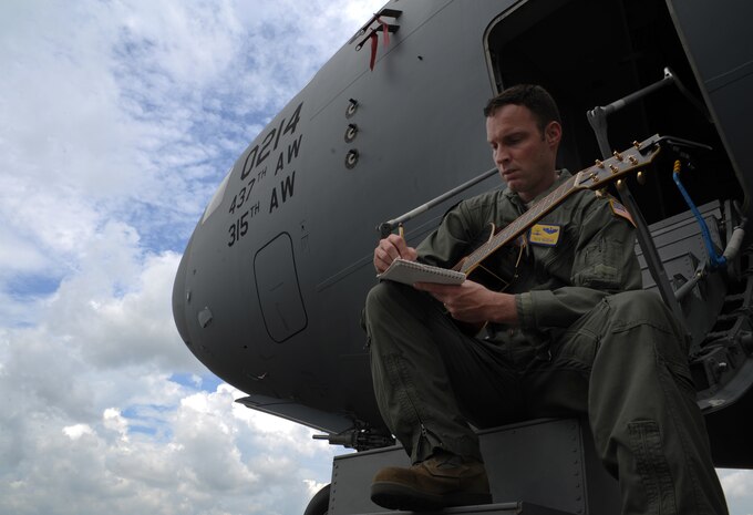 Major Pete Reddan, 437th Airlift Wing pilot, writes a song outside of a C-17 Globemaster III on Joint Base Charleston, S.C.  June 13, 2012. Reddan's military inspired tune, "Off to War", was recently recorded by Nashville recording artist, Brad Anderson. The song was inspired by his experiences during deployments, as well as the experiences of the men and women Reddan serves with. (U.S. Air Force photo/Airman 1st Class Ashlee Galloway)
