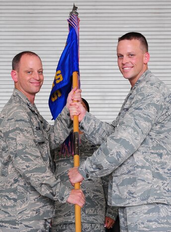Colonel James Clavenna, 437th Maintenance Group commander, hands the squadron guidon to Lt. Col. Tracey Smith, 437th Maintenance Squadron incoming commander, during the 437th MXS change of command ceremony at Joint Base Charleston - Air Base, S.C, June 11, 2012. The handing over of the guidon symbolizes the changing of a command. (U.S. Air Force photo/ Airman 1st Class Chacarra Walker)