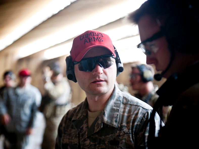 U.S. Air Force Staff Sgt. David Deel, 38th Rescue Squadron combat arms training and maintenance instructor, discusses firing adjustments with Senior Airman Brandon Smith, 38th Rescue Squadron pararescueman, during combat arms training June 12, 2012, at Moody Air Force Base, Ga. CATM instructors guide Airmen during firing to ensure they qualify on their weapons and uphold safety standards throughout all CATM courses. (U.S. Air Force photo by Staff Sgt. Jamal D. Sutter/Released)  