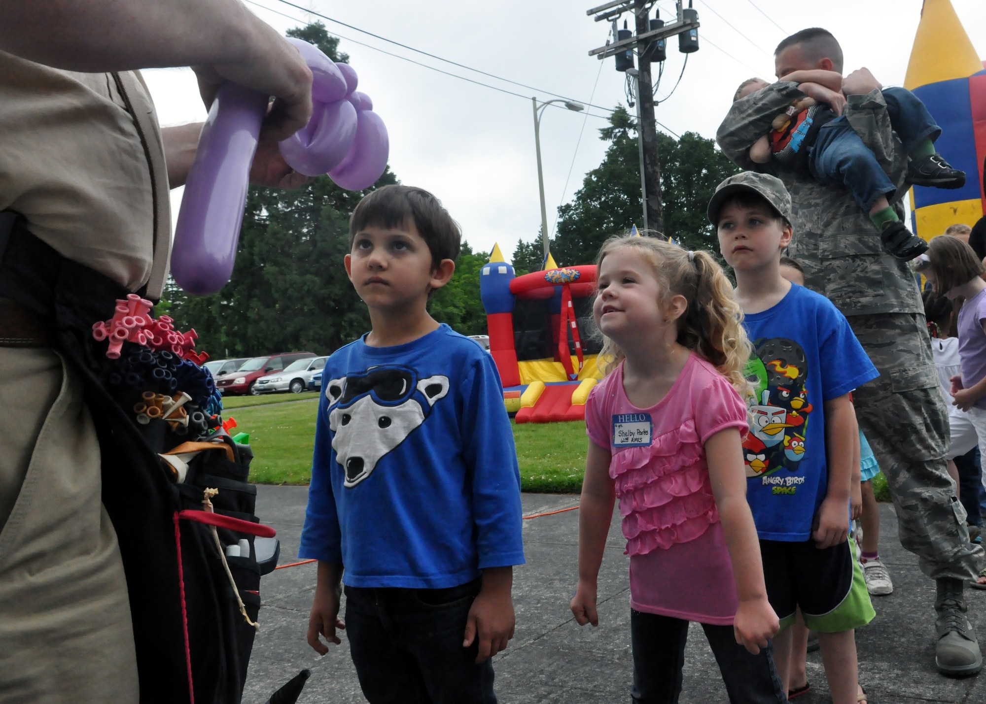 Children wait in line for balloon animals during the quarterly Deployed Families Dinner June 11, 2012, at the McChord Field Chapel Support Center on Joint Base Lewis-McChord, Wash. (U.S. Air Force photo/Senior Airman Leah Young)