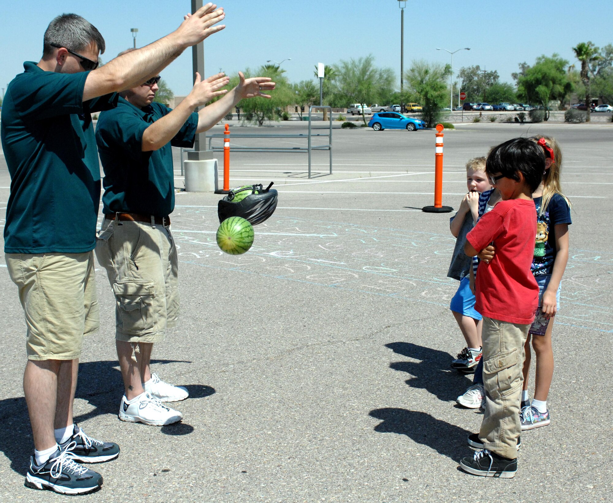 U.S. Air Force Tech. Sgt. Ross Weatherford (left) and Staff Sgt. Matthew Anderson (right), both from the 355th Fighter Wing Ground Safety Office, demonstrate the benefits of wearing a bicycle helmet to children at the Bicycle Rodeo held in the Base Exchange parking lot on Davis-Monthan Air Force Base, Ariz., June 9, 2012. The demonstration utilized watermelons to show the protection offered by a helmet. (U.S. Air Force photo by Airman 1st Class Saphfire Cook/Released)