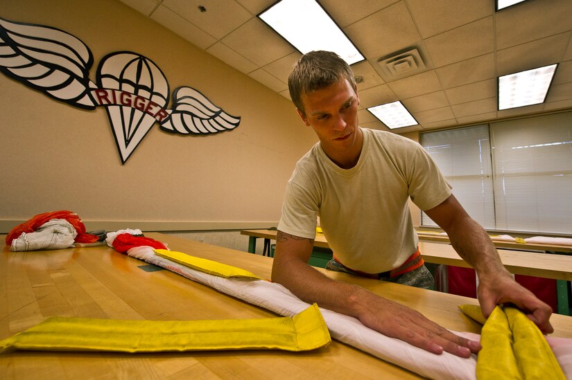 Senior Airman Benjamin Leis, an aircrew flight equipment technician with the 437th Operations Support Squadron out of Joint Base Charleston - Air Base, S.C., prepares a parachute to be packed for a C-17A Globemaster III, June 8, 2012. The Airmen swap out and inspect equipment for C-17A alert aircraft on standby every 30 days. (U.S. Air Force photo by Airman 1st Class George Goslin/Released)