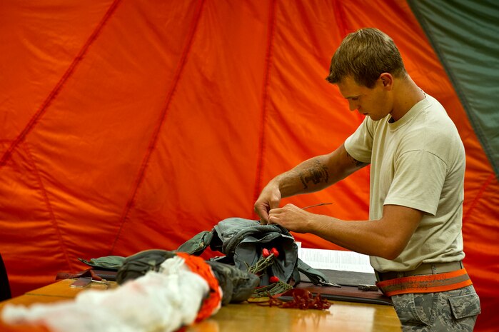 Senior Airman Benjamin Leis, an aircrew flight equipment technician with the 437th Operations Support Squadron out of Joint Base Charleston - Air Base, S.C., prepares a parachute to be packed for a C-17A Globemaster III, June 8, 2012. The Airmen swap out and inspect equipment for C-17A alert aircraft on standby every 30 days. (U.S. Air Force photo by Airman 1st Class George Goslin/Released)