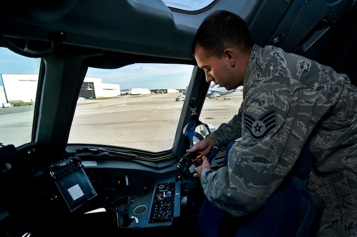 Staff Sgt. Kyle Pratt, an aircrew flight equipment technician with the 437th Operations Support Squadron out of Joint Base Charleston - Air Base, S.C., swaps out Quick Don oxygen masks on a C-17A Globemaster III, June 8, 2012. The Airmen swap out and inspect equipment for C-17A alert aircraft on standby every 30 days. (U.S. Air Force photo by Airman 1st Class George Goslin/Released)