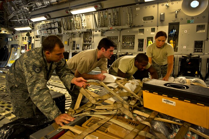 Staff Sgt. Kyle Pratt, Senior Airman Timothy Wochnick, Staff Sgt. Ralph Miller, and Staff Sgt. Sharon Clark, aircrew flight equipment technicians with the 437th Operations Support Squadron out of Joint Base Charleston - Air Base, S.C, strap down the alert kit on a C-17A Globemaster III, June 8, 2012. The Airmen swap out and inspect equipment for C-17A alert aircraft on standby every 30 days. (U.S. Air Force photo by Airman 1st Class George Goslin/Released)